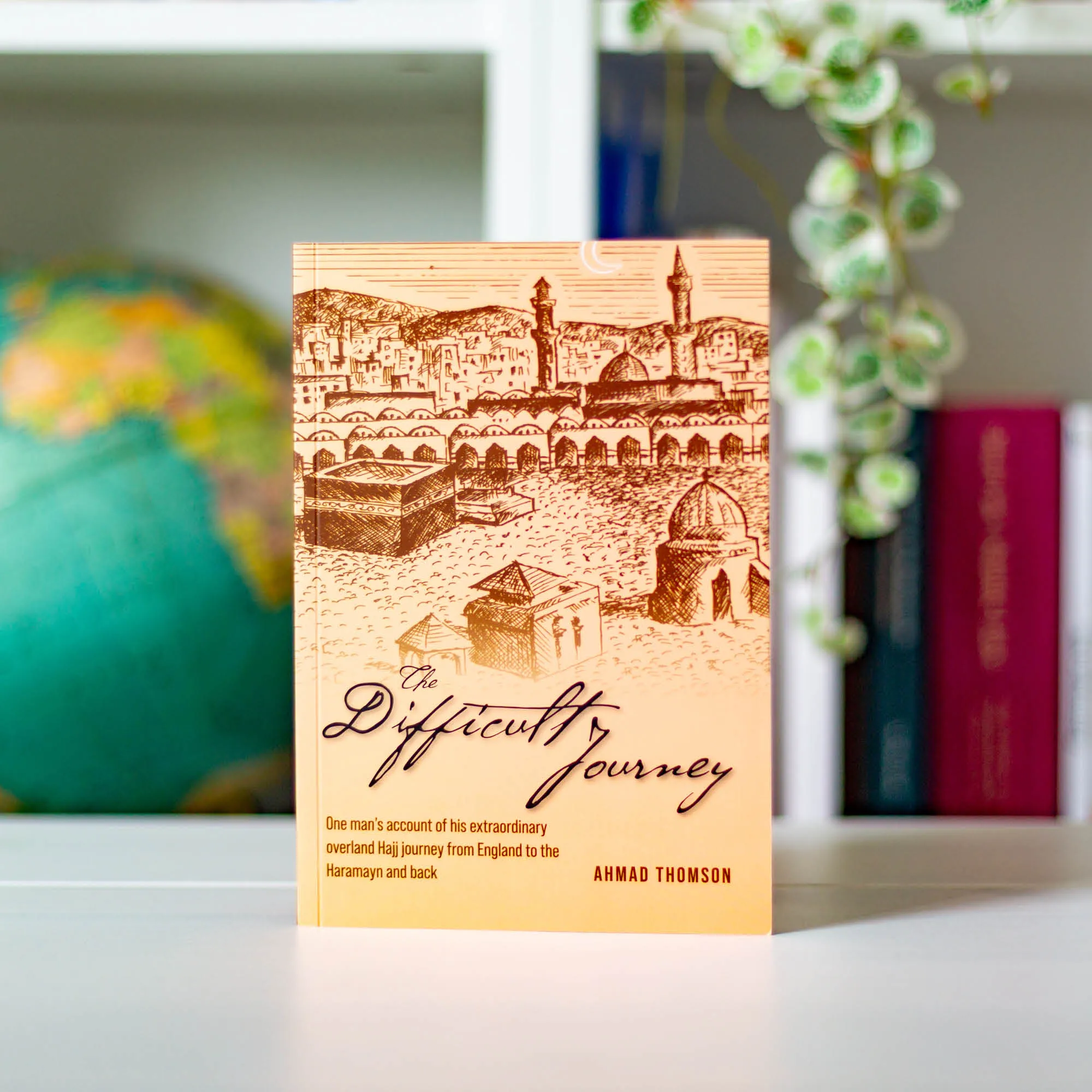 Upright book in library of The Difficult Journey by Ahmad Thomson. Hajj travelogue by Ta-Ha Publishers