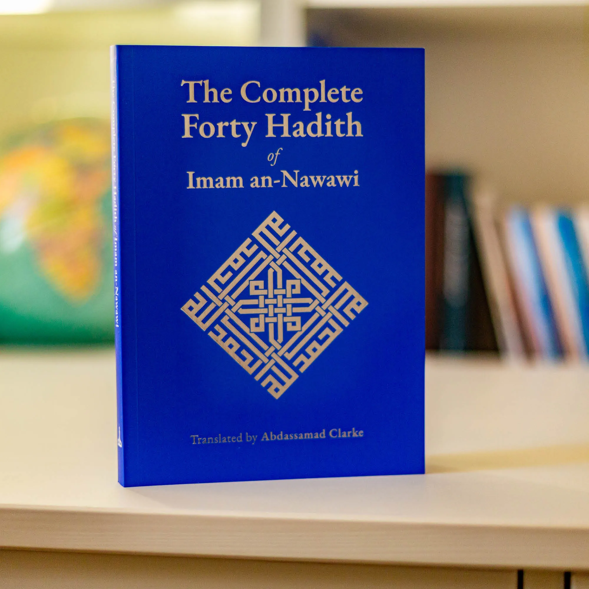 Upright book in library of The Complete Forty Hadith of Imam an-Nawawi, Abdassamad Clarke. Forty hadith collection by Ta-Ha Publishers.