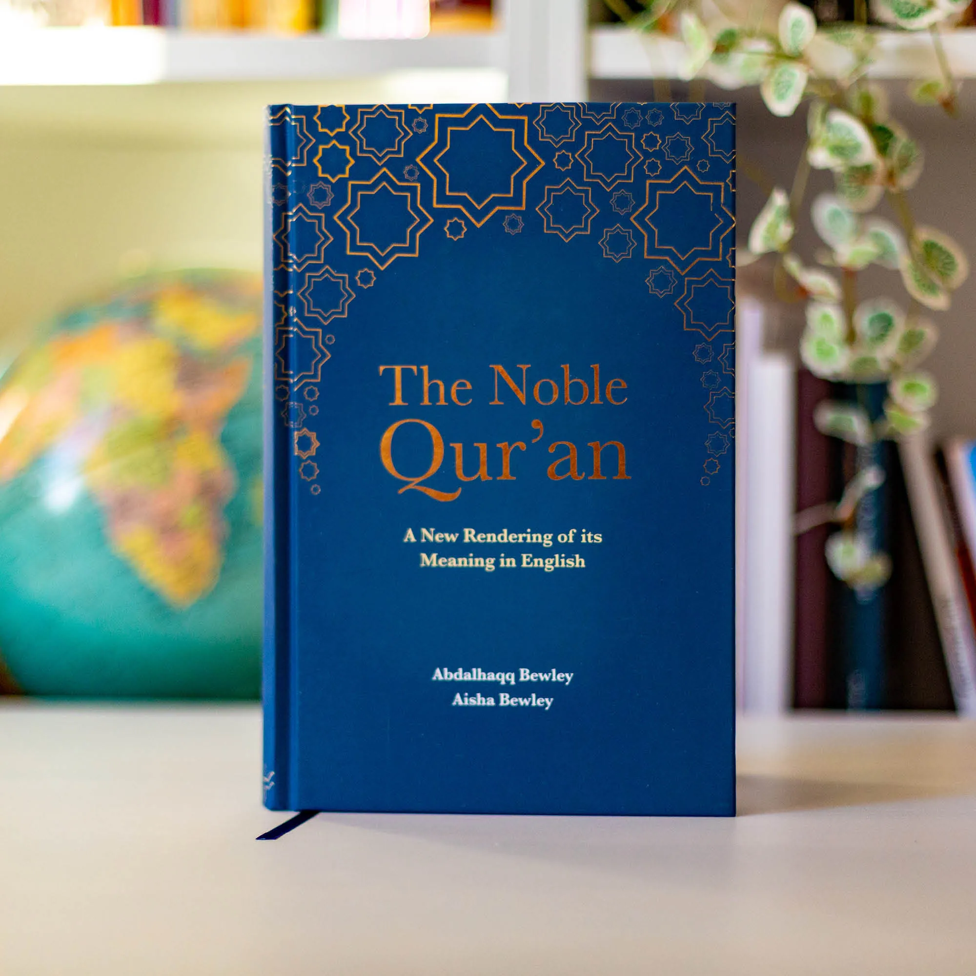 Upright book in library of The Noble Qur’an by Abdalhaqq & Aisha Bewley. English Qur’an translation by Ta-Ha Publishers