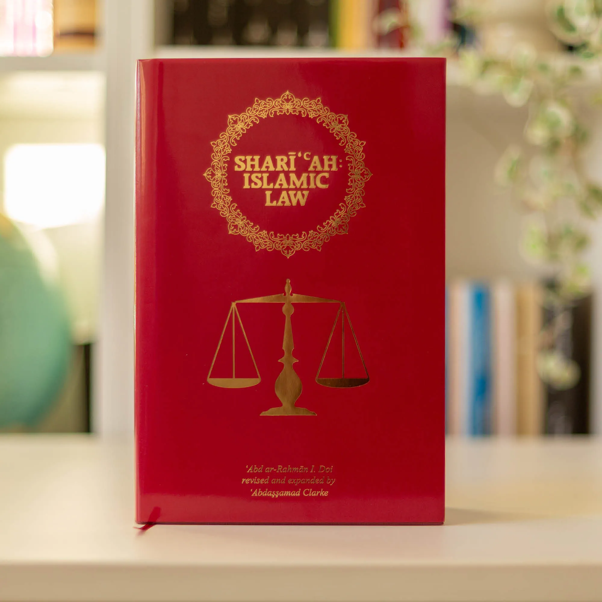 Upright book in library of Shari‘ah: Islamic Law by Abd ar-Rahman I. Doi, Abdassamad Clarke. Islamic Law textbook by Ta-Ha Publishers